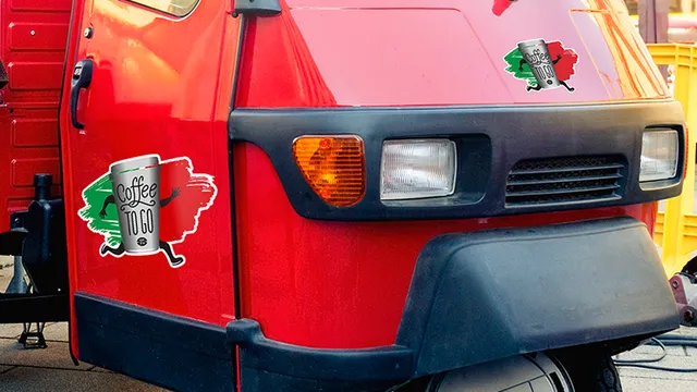 Véhicule rouge avec un autocollant Trotec coloré découpé au laser indiquant "Coffee to go" (café à emporter).